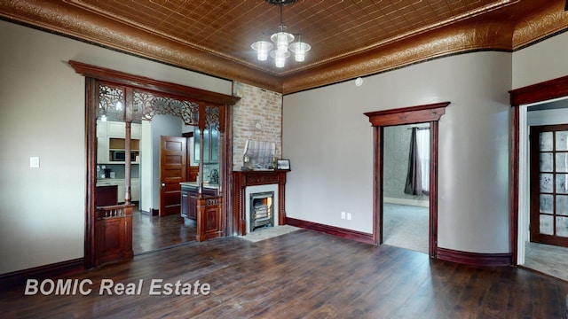 interior space with a towering ceiling, dark hardwood / wood-style floors, an inviting chandelier, and crown molding