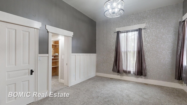 interior space featuring light carpet and a chandelier