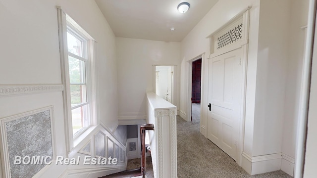 corridor featuring light colored carpet