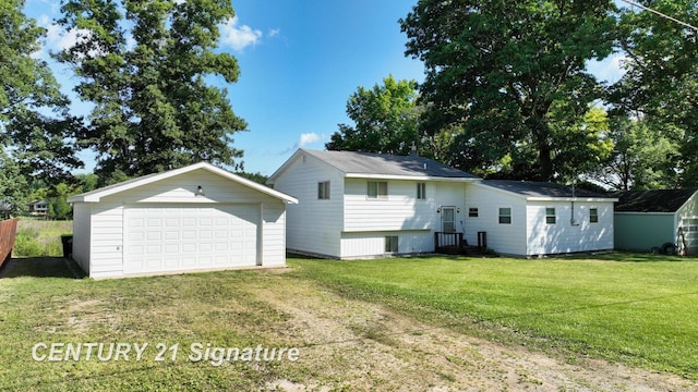 back of property with a lawn, a garage, and an outdoor structure