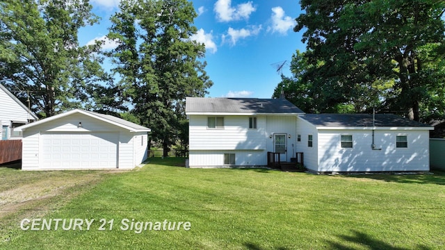 rear view of property featuring a lawn, an outdoor structure, and a garage