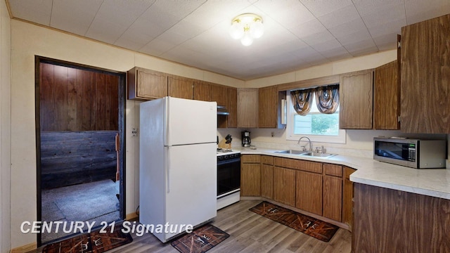 kitchen featuring white appliances, sink, and light hardwood / wood-style flooring