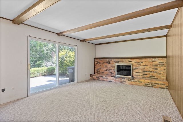 unfurnished living room featuring wooden walls, beamed ceiling, carpet floors, and a brick fireplace