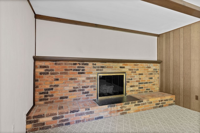 room details featuring wood walls, a fireplace, and carpet