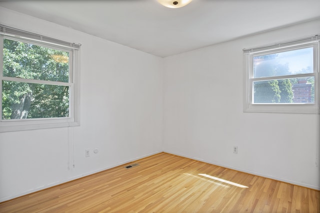 unfurnished room featuring hardwood / wood-style flooring and a wealth of natural light