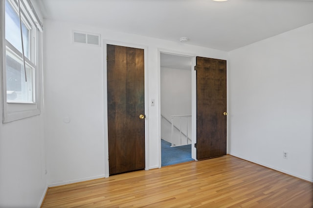 unfurnished bedroom with a closet and light hardwood / wood-style floors