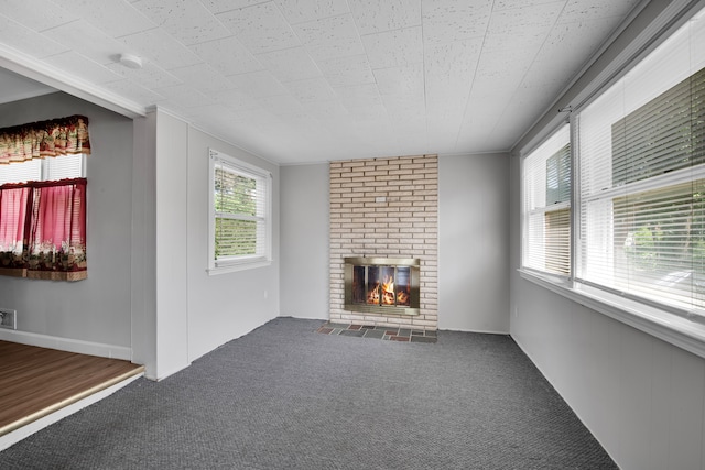 unfurnished living room featuring carpet floors and a brick fireplace