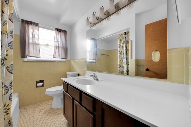 bathroom featuring tile patterned floors, vanity, toilet, and tile walls