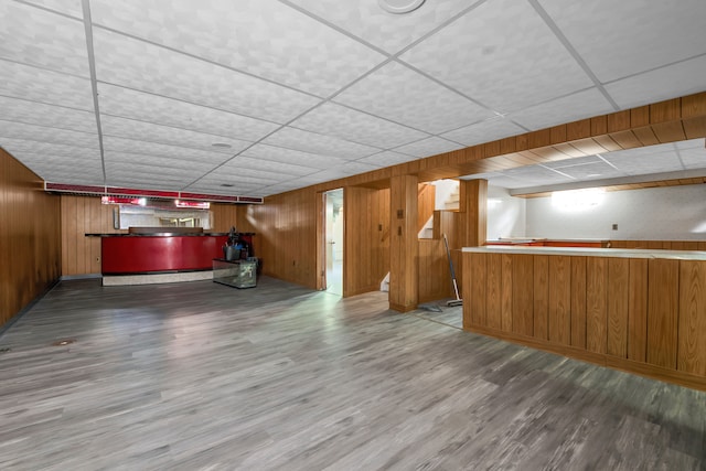 bar featuring hardwood / wood-style flooring, a paneled ceiling, and wood walls