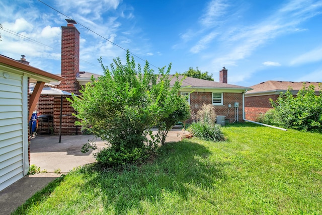 back of house with a patio area and a yard