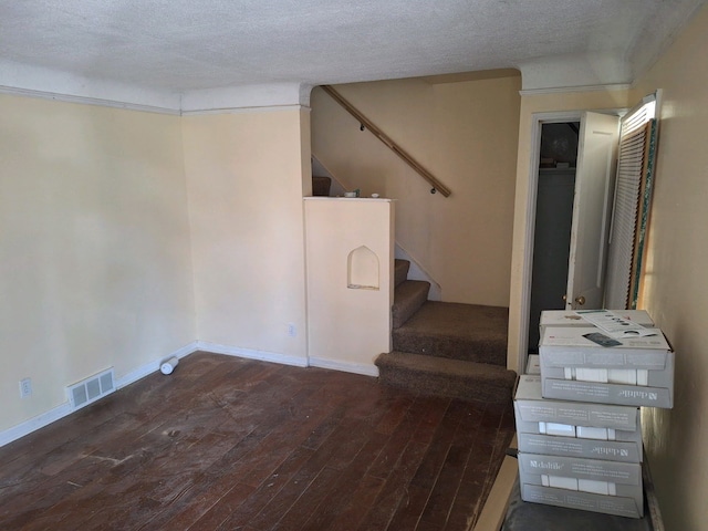 stairway with hardwood / wood-style floors and a textured ceiling