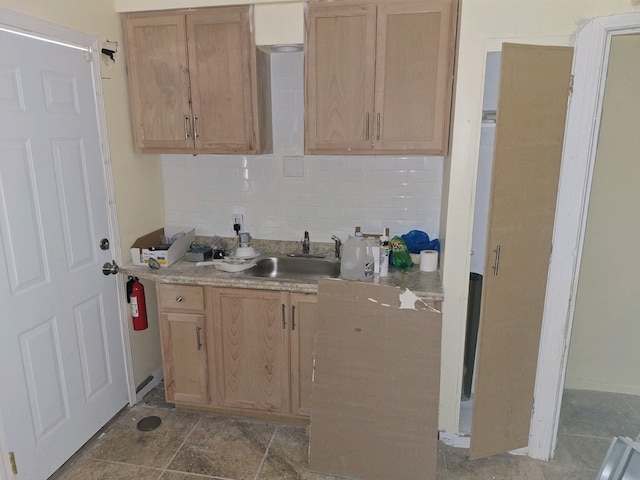 kitchen featuring light brown cabinets, sink, and tasteful backsplash