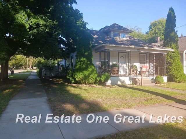 bungalow-style home with covered porch and a front lawn