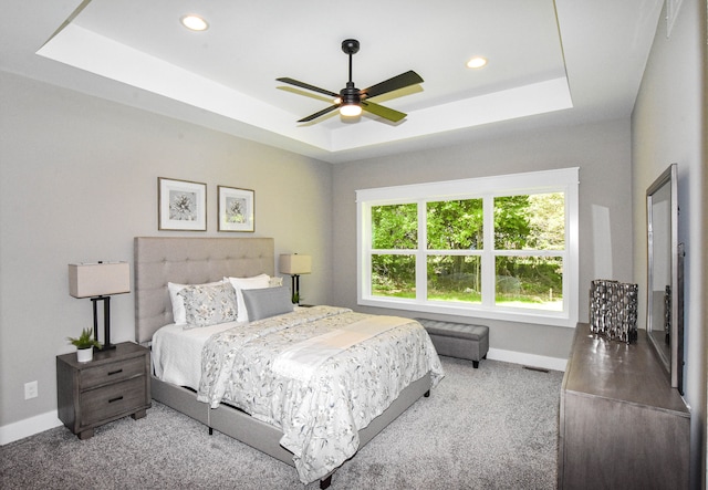 bedroom featuring ceiling fan, a raised ceiling, and carpet floors