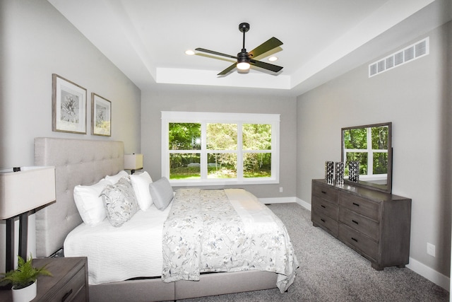 bedroom featuring a tray ceiling, ceiling fan, and light carpet