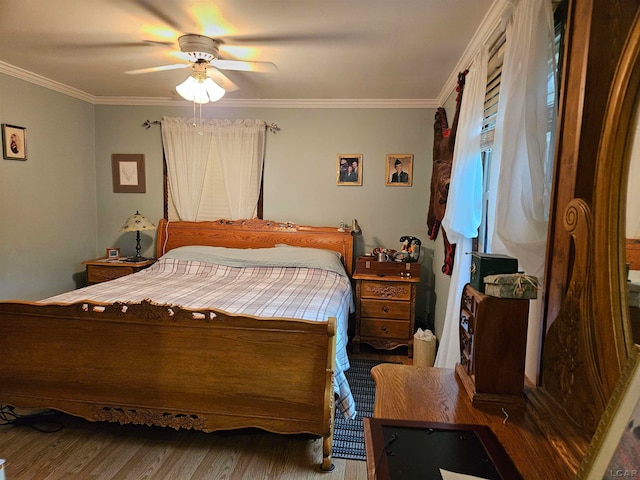 bedroom featuring dark hardwood / wood-style flooring, ceiling fan, and crown molding