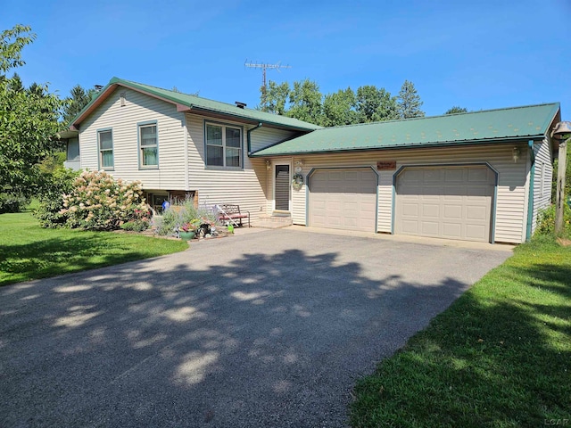 tri-level home featuring a front lawn and a garage