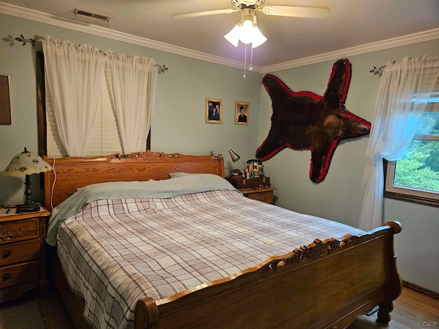 bedroom featuring hardwood / wood-style floors, ceiling fan, and ornamental molding