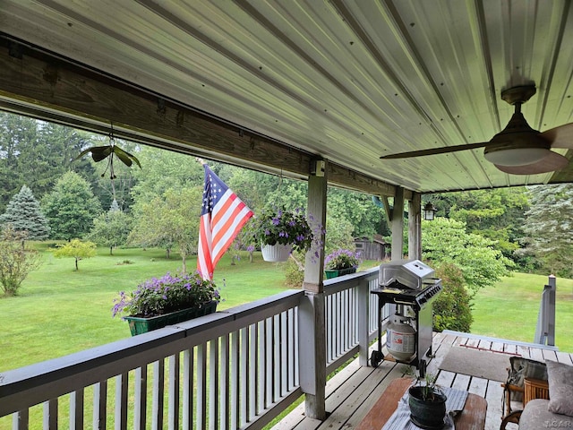 deck with a grill, ceiling fan, and a yard