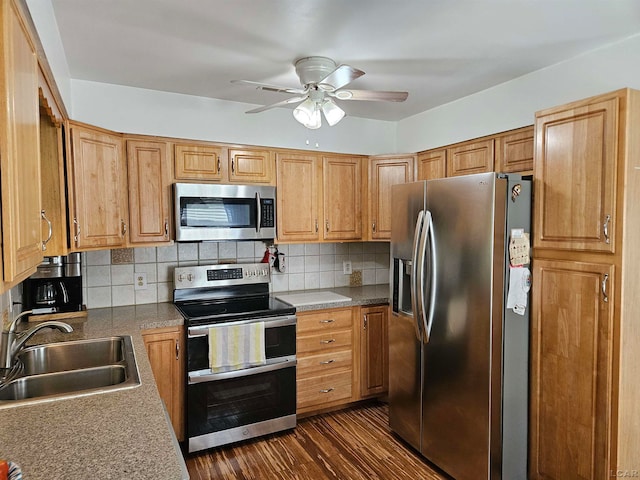 kitchen featuring ceiling fan, sink, tasteful backsplash, dark hardwood / wood-style flooring, and appliances with stainless steel finishes