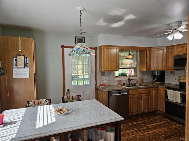 kitchen featuring appliances with stainless steel finishes, dark hardwood / wood-style flooring, backsplash, sink, and hanging light fixtures