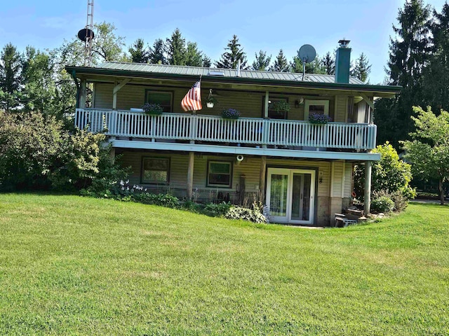 rear view of property with a wooden deck and a lawn