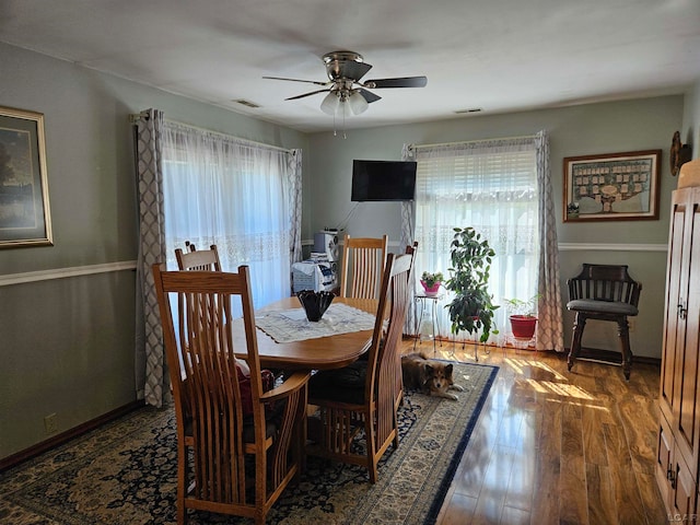 dining area with ceiling fan, plenty of natural light, and dark hardwood / wood-style floors