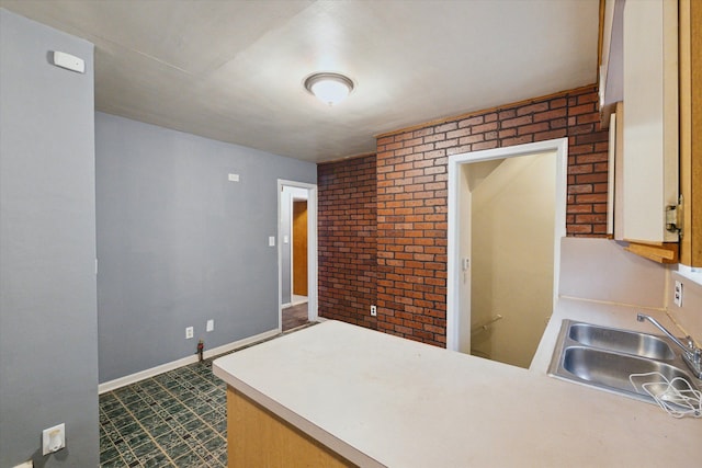 kitchen with brick wall and sink