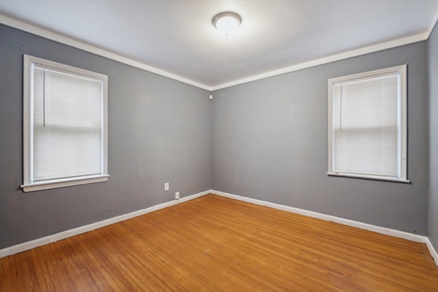 unfurnished room featuring wood-type flooring and ornamental molding