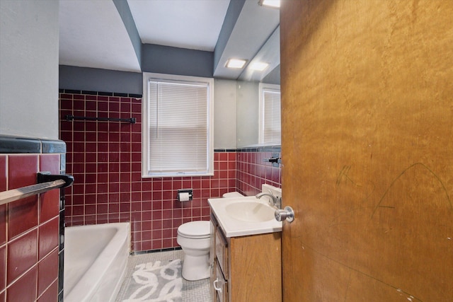 bathroom featuring vanity, tile walls, tile patterned flooring, toilet, and a tub