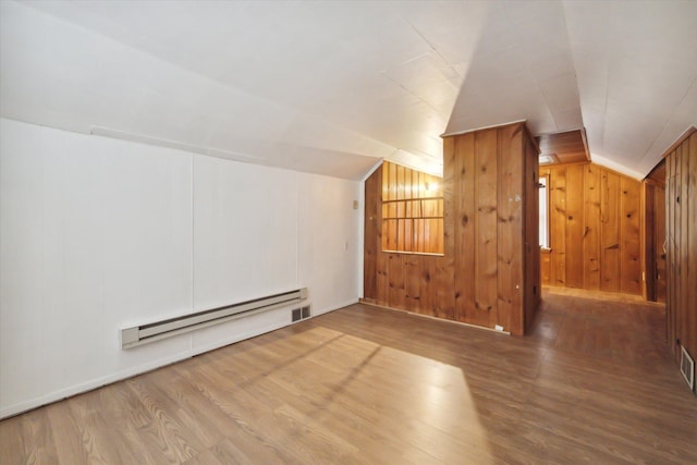 additional living space with hardwood / wood-style floors, lofted ceiling, and wooden walls