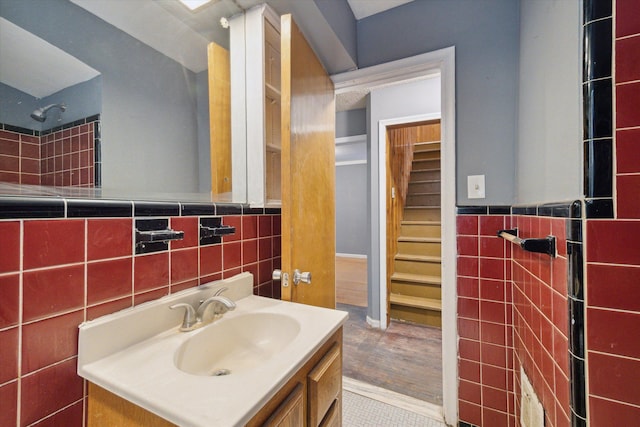 bathroom featuring vanity, wood-type flooring, and tile walls