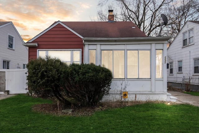 view of front of home featuring a sunroom and a yard