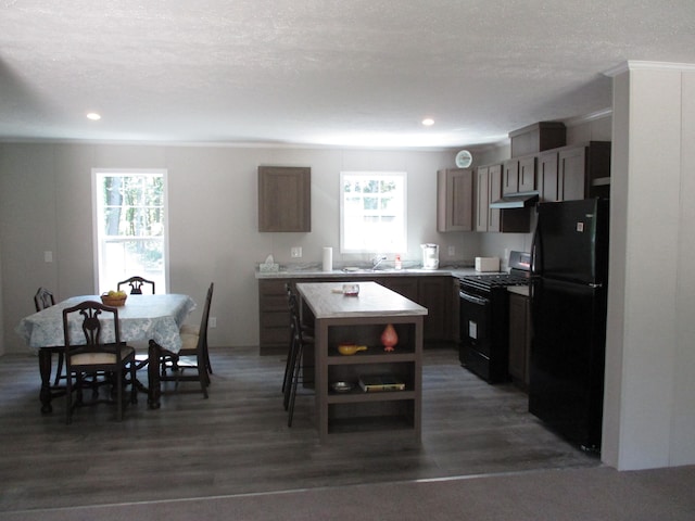 kitchen featuring a center island, dark wood-type flooring, a healthy amount of sunlight, and black appliances