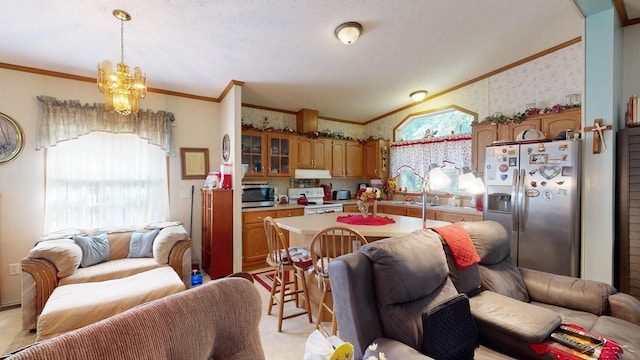 kitchen featuring crown molding, hanging light fixtures, appliances with stainless steel finishes, and an inviting chandelier