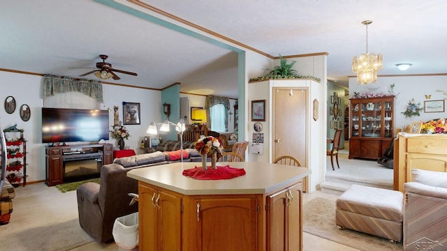 kitchen with pendant lighting, ceiling fan with notable chandelier, a center island, and light carpet