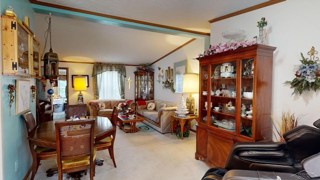 carpeted dining room with lofted ceiling and crown molding