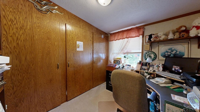 carpeted home office with a textured ceiling, vaulted ceiling, ornamental molding, and wood walls