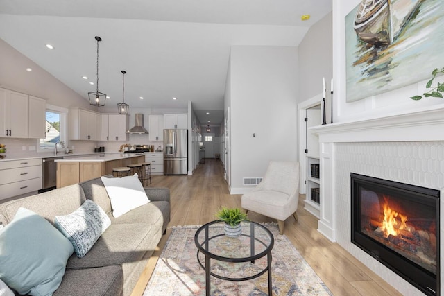 living room featuring light wood-type flooring and vaulted ceiling