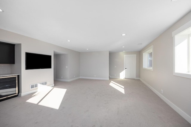 unfurnished living room featuring light colored carpet