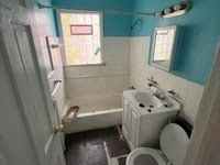 bathroom with vanity, toilet, tile walls, and a tub