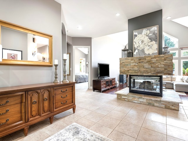 tiled living room with a fireplace and high vaulted ceiling