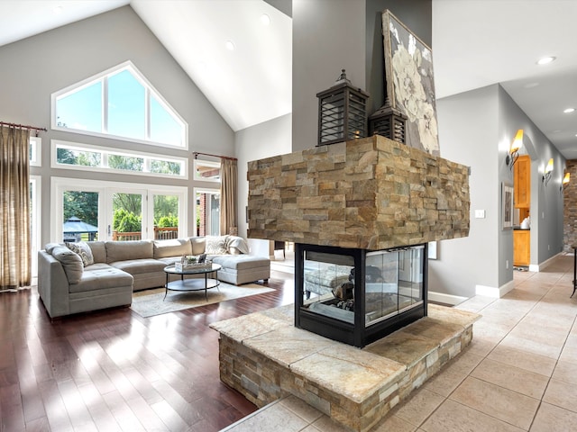 living room with a fireplace, hardwood / wood-style floors, and high vaulted ceiling