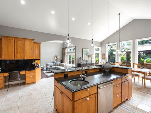 kitchen featuring light tile patterned floors, a kitchen island with sink, and a wealth of natural light