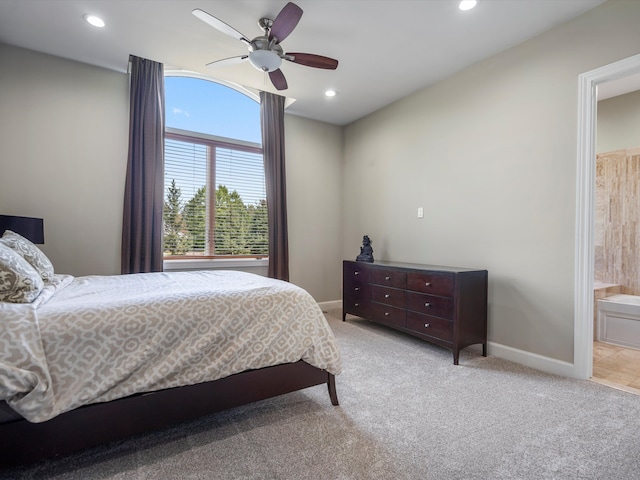 carpeted bedroom with ensuite bathroom and ceiling fan