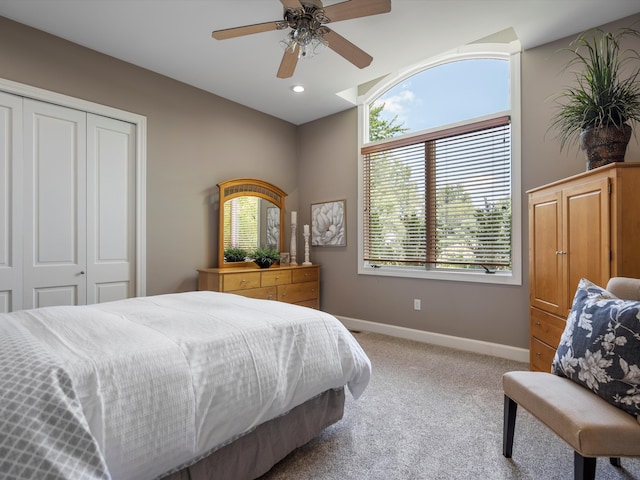 carpeted bedroom with ceiling fan, a closet, and multiple windows