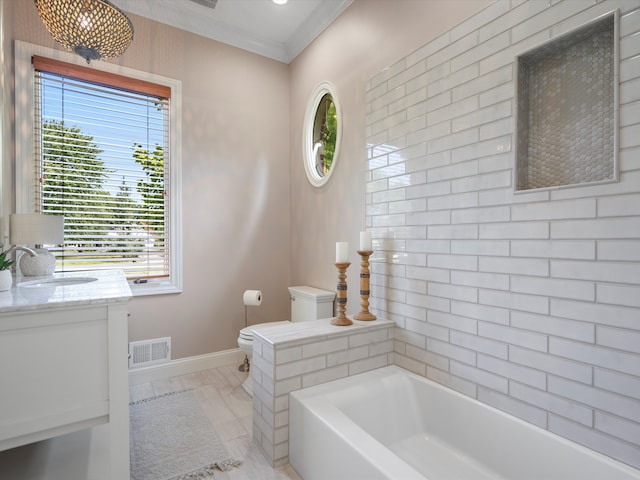 bathroom with a bathing tub, crown molding, vanity, and toilet