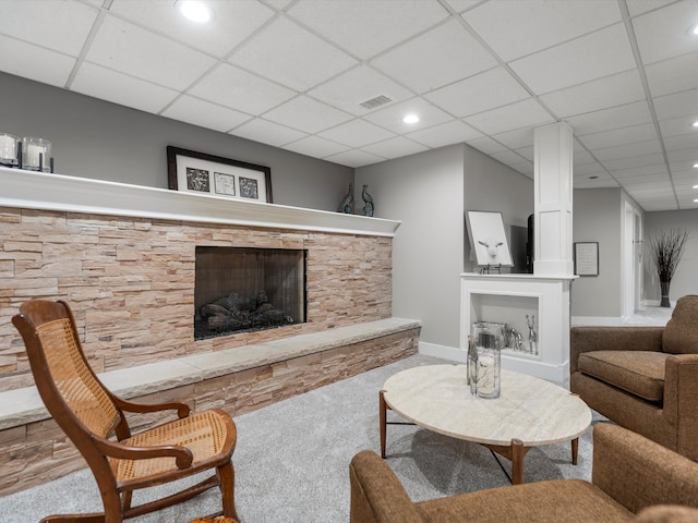 carpeted living room with a fireplace and a paneled ceiling