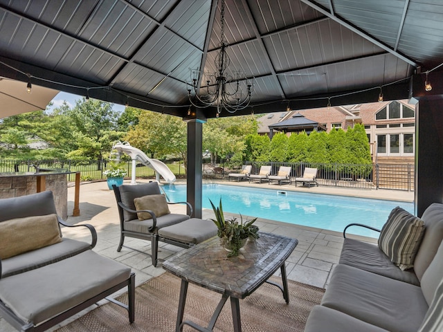 view of pool featuring an outdoor living space, a water slide, and a patio