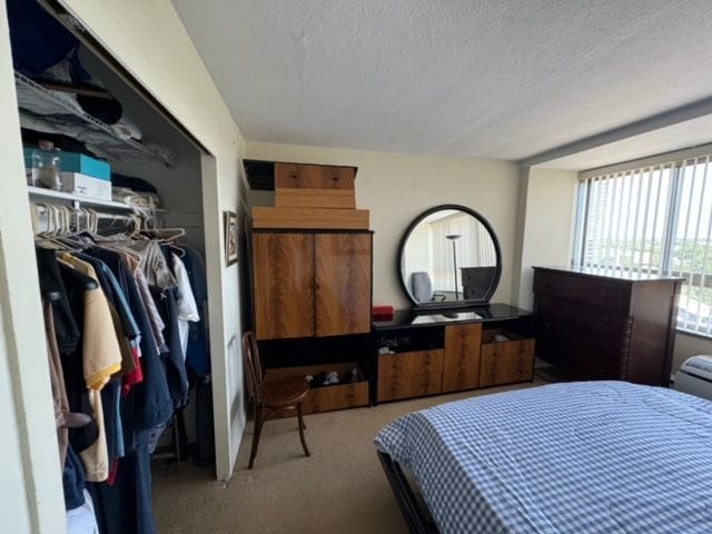 carpeted bedroom featuring a closet and a textured ceiling